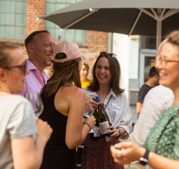 Weinfreunde amüsieren sich mit Weinflaschen im Freien
