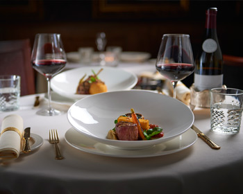 Feines Essen und Rotwein-Arrangement am Tisch
