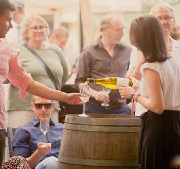 Weinverkostung auf einem Weinfest, Wein wird eingeschenkt
