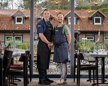 Zwei Köche mit Weinexperten im Restaurant