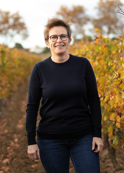 Winzerin in Weinbergen, Herbst, Weinanbau, Lächeln, Sonnenlicht