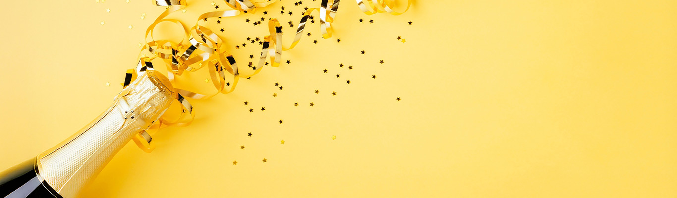 Sektflasche gelber Hintergrund Konfetti jubiläum