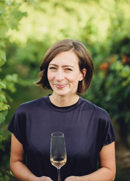 Winzerin mit Glas Roséwein im Weinberg