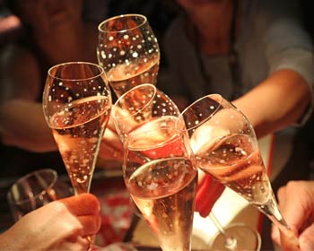 Anstoß mit Gläsern Roséwein, Feierlichkeit