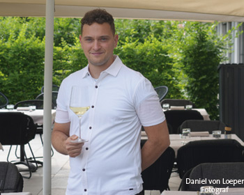 Sommelier hält Weißweinglas auf der Terrasse